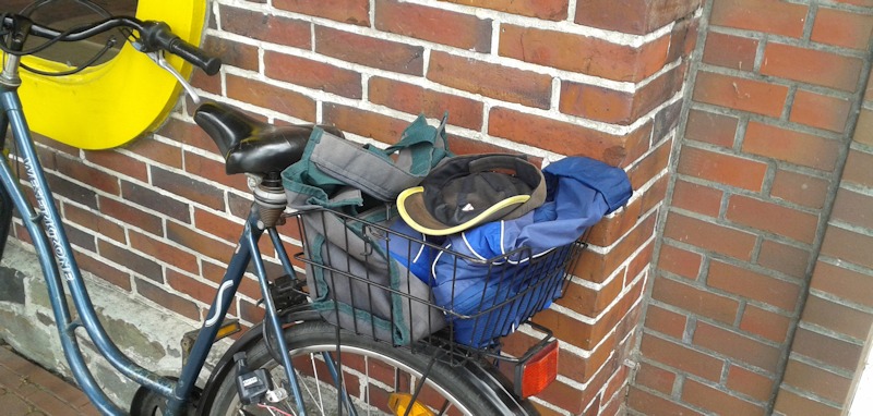 Fahrradkorb hinten auf dem Gepäckträger mit Arbeitskleidung