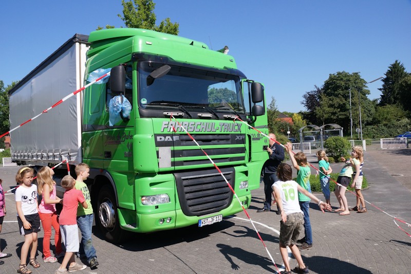 Kinder stehen neben LKW und bekommen den toten Winkel erklärt