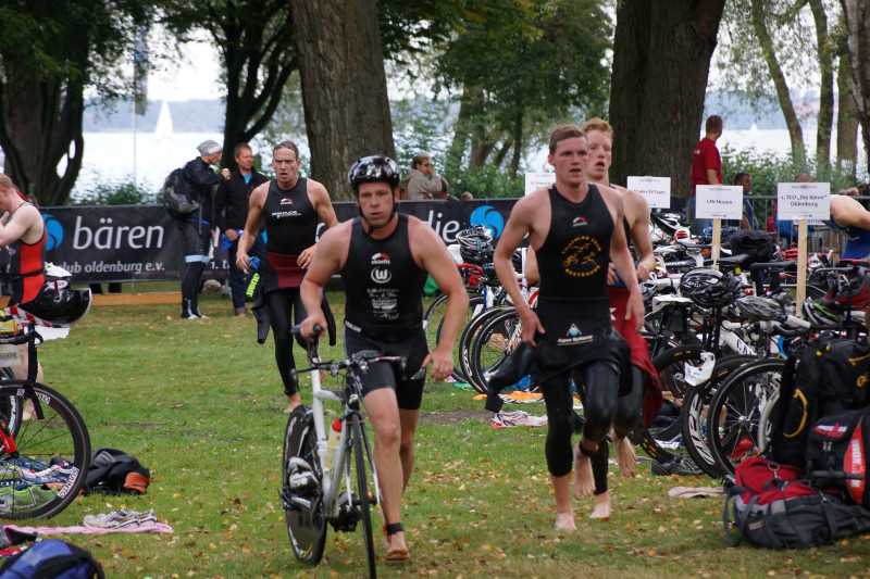 Triathleten rennen mit dem Fahrrad